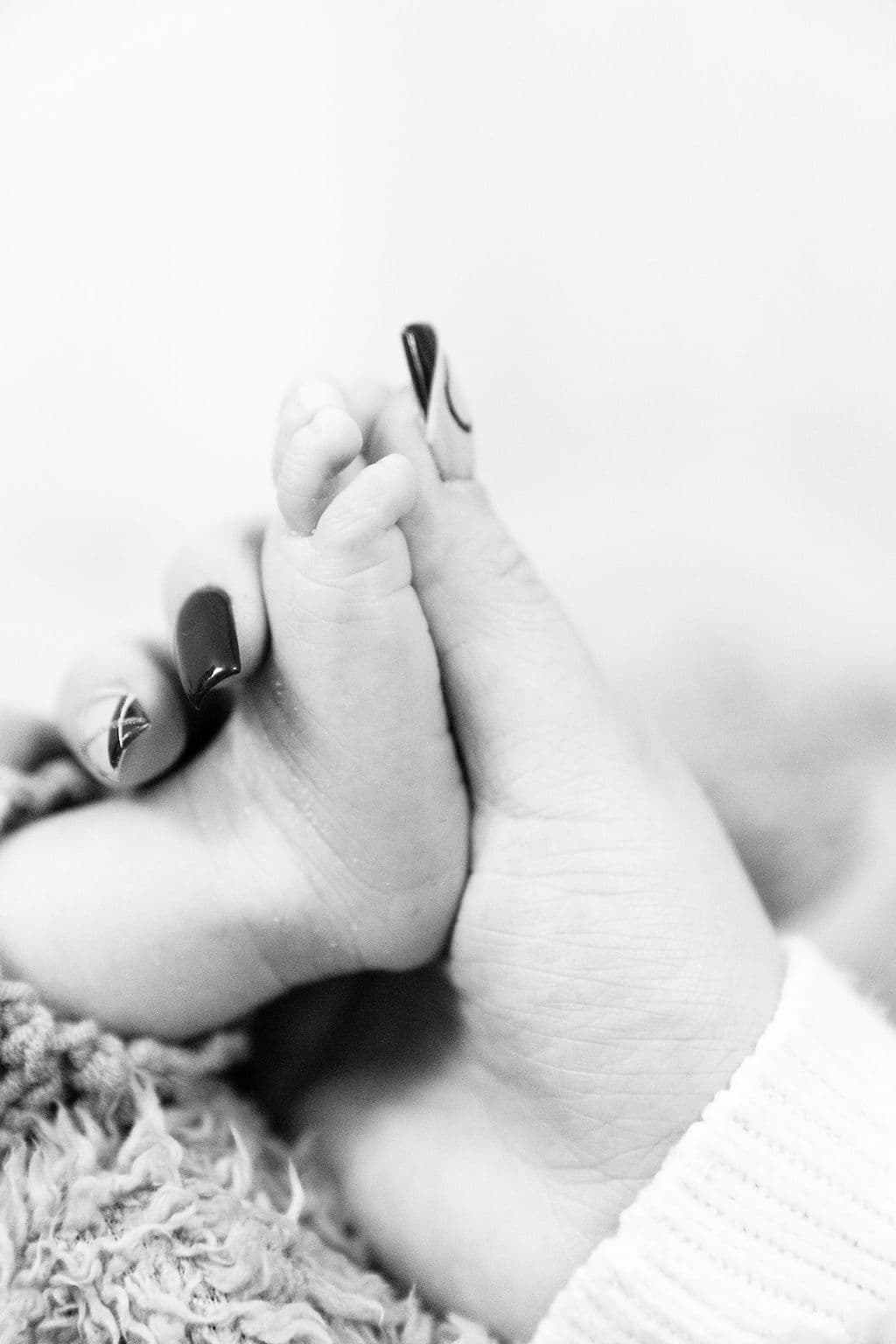 Newborn feet cradled in hands