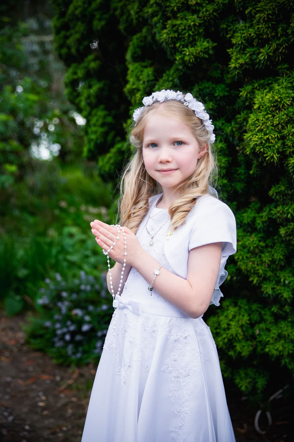 Girl in communion dress in garden