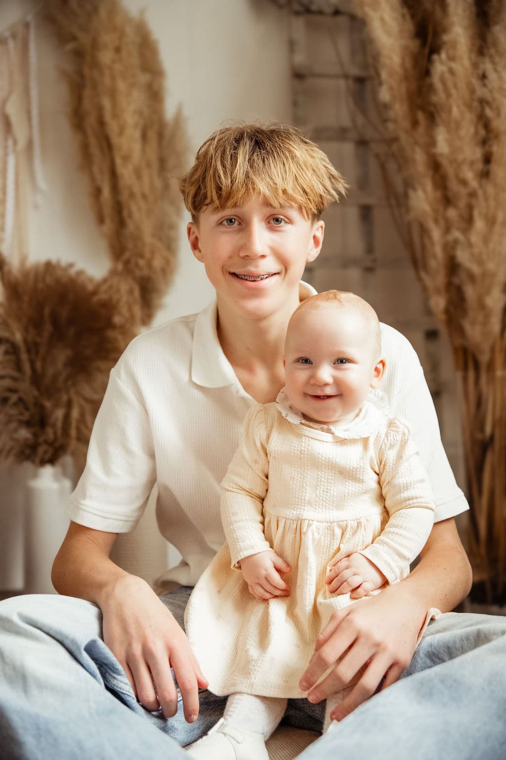 Older sibling holding baby in studio