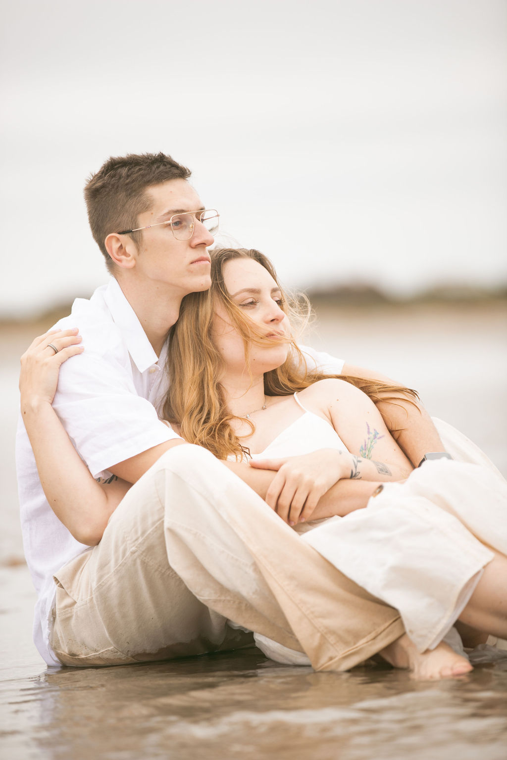 Couple sitting on wet sand at the beach